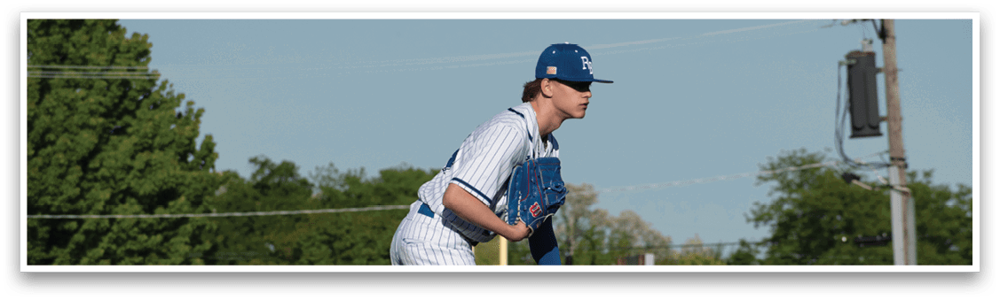A baseball player in a blue and white uniform is pitching a ball. Description generated by AI