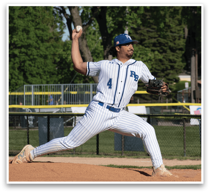 A baseball player in a blue and white uniform is pitching a ball. Description generated by AI
