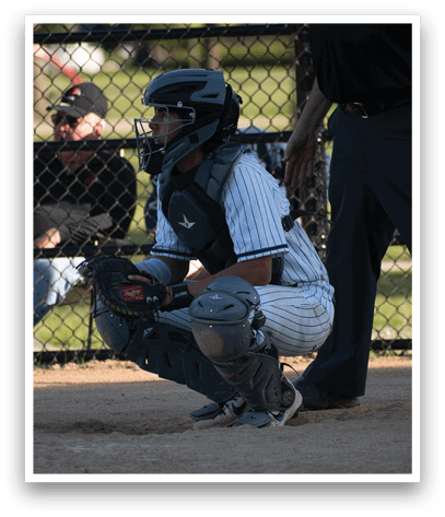 A baseball player in a catcher's position. Description generated by AI