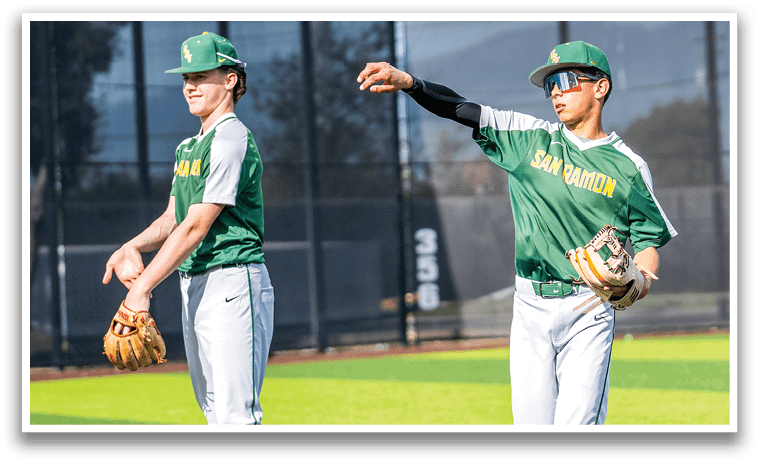 Two baseball players wearing green and white uniforms are standing on a field. One player is pointing up, while the other is holding a baseball glove. AI generated content
