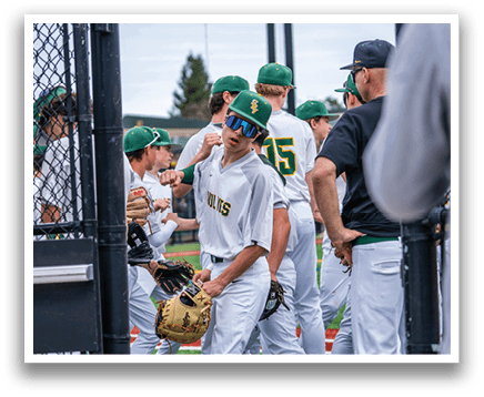 A group of baseball players wearing green and white uniforms are standing on a field. AI generated content