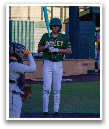 A baseball player in a green and yellow uniform stands on a field holding a bat, ready to play. AI generated content