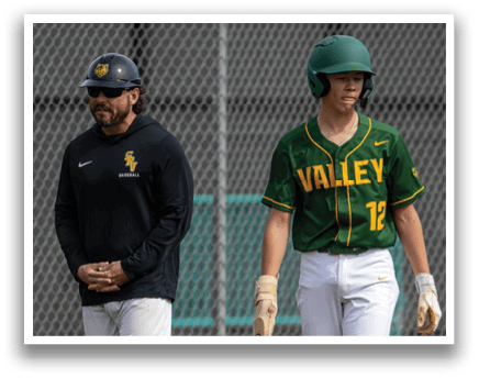 A man wearing a green helmet and a baseball uniform walks on a field. Another man, wearing a black shirt, watches him. AI generated content