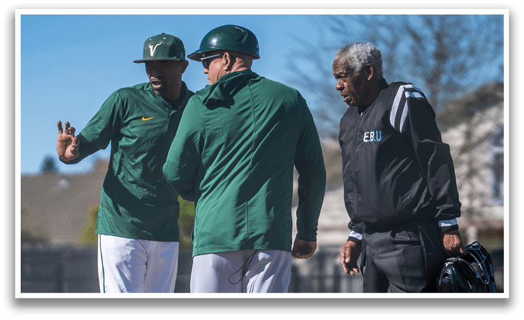 Three men are standing on a baseball field, engaged in conversation. One man is wearing a baseball uniform, while the other two are dressed in regular clothing. The man in the uniform is pointing, possibly giving instructions to the other two men. AI generated content