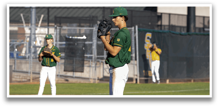 A baseball player in a green shirt and white pants is holding a baseball glove. Description generated by AI