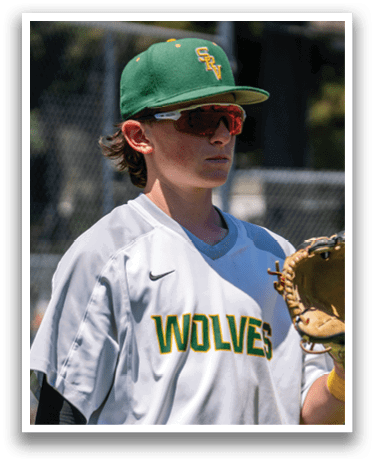 A baseball player wearing a white and green shirt with the word wolves on it. Description generated by AI