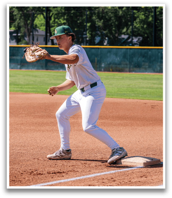 A baseball player in a white uniform is catching a ball. Description generated by AI