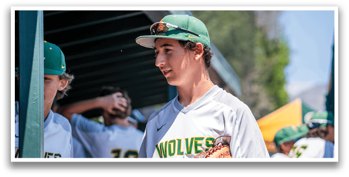 A man wearing a baseball cap and a white shirt with the word wolves on it. Description generated by AI