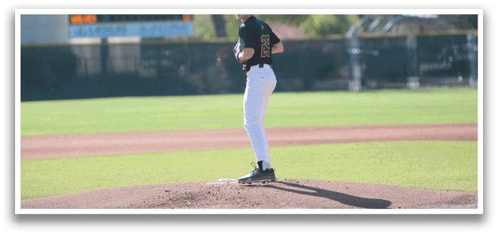 A baseball player is standing on the pitcher's mound, wearing a black shirt and white pants. He is holding a baseball in his hand, preparing to throw it. AI generated content