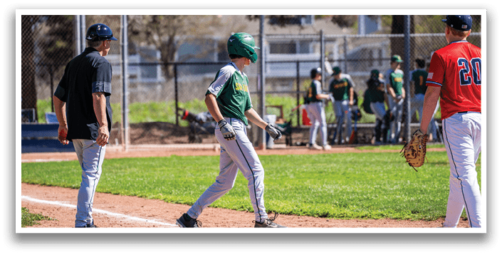 A baseball game is in progress with a player running to home plate. The player is wearing a green helmet and is holding a bat. There are several other players on the field, some of whom are holding baseball gloves. A bench is visible in the background. AI generated content