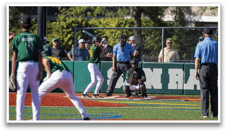 A baseball game is in progress with a batter, catcher, and umpire on the field. The batter is holding a bat and preparing to swing. The catcher is wearing a baseball glove, ready to catch the ball. The umpire is standing behind the catcher, closely observing the play. There are several other people in the scene, likely teammates, coaches, or spectators. AI generated content