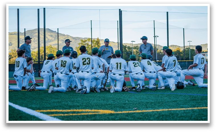 A group of young men are sitting on a field, wearing baseball uniforms. They are listening to a coach, who is giving them instructions. AI generated content