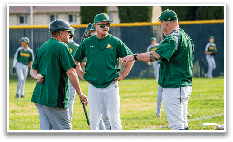 A group of men wearing green shirts are standing on a baseball field. They are holding baseball bats and talking to each other. AI generated content