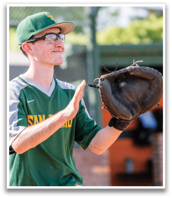 A man wearing a baseball glove and a green and yellow shirt is holding his glove up to his face. AI generated content
