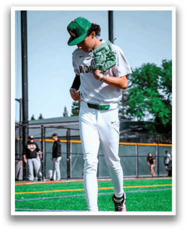 A baseball player in a white uniform with a green stripe on the side. Description generated by AI