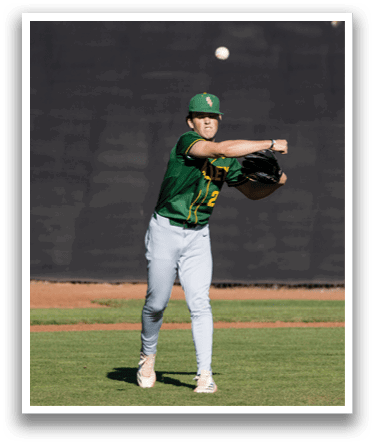 A baseball player wearing a green shirt and white pants is throwing a ball. Description generated by AI