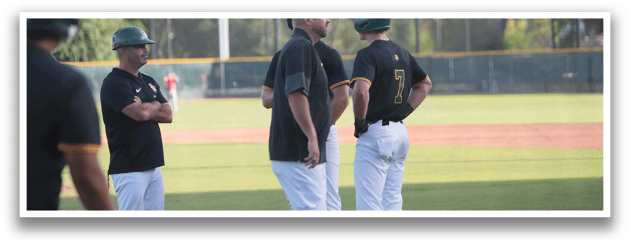 A group of men wearing black and white uniforms are standing on a baseball field. Description generated by AI