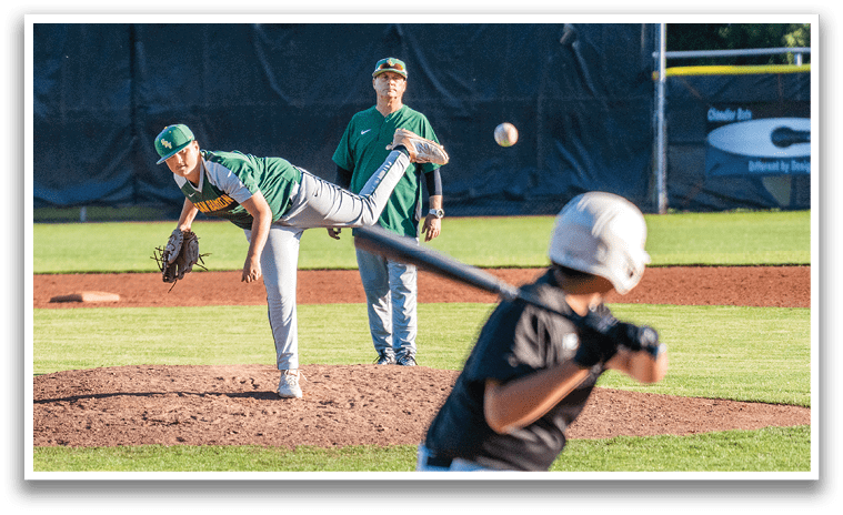 A baseball player in a green shirt and gray pants is throwing a ball. Description generated by AI