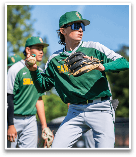 A baseball player wearing a green and white uniform is holding a baseball. Description generated by AI