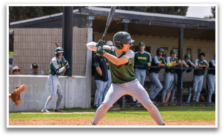 A baseball player in a green shirt and white pants is swinging a bat. Description generated by AI