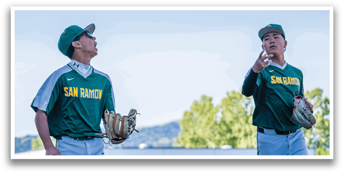 Two baseball players wearing green and white uniforms. Description generated by AI