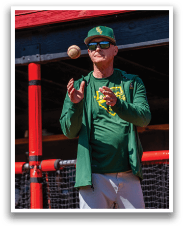 A man wearing a green hat and jacket is throwing a baseball. Description generated by AI