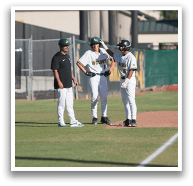 Three men standing on a baseball field. Description generated by AI