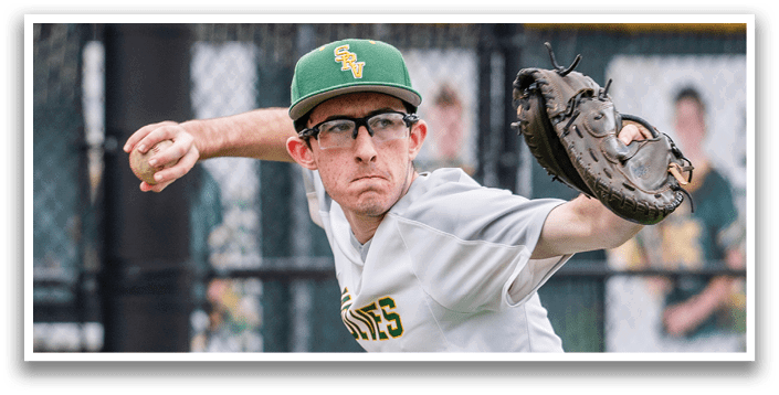 A baseball player wearing a green and white hat and glasses, preparing to throw a ball. Description generated by AI