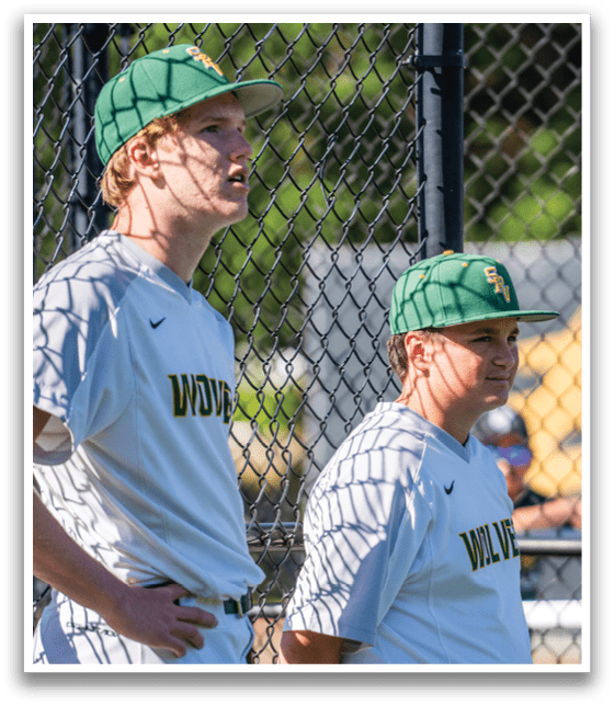 Two baseball players wearing white uniforms. Description generated by AI