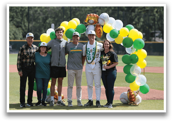 A group of people standing on a baseball field. Description generated by AI