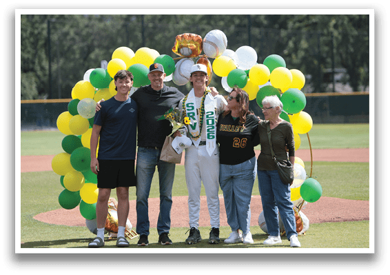 A group of people standing on a baseball field. Description generated by AI