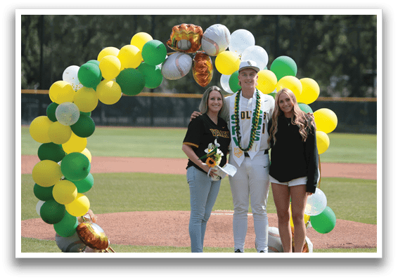 A group of people standing in front of a baseball field. Description generated by AI