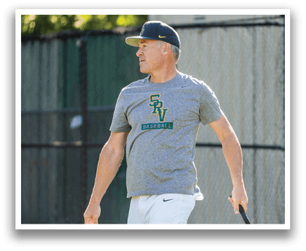 A man wearing a gray shirt with a baseball logo on it. Description generated by AI
