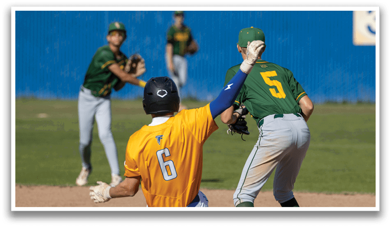 A baseball player wearing a yellow shirt and blue pants is trying to catch a ball. Description generated by AI