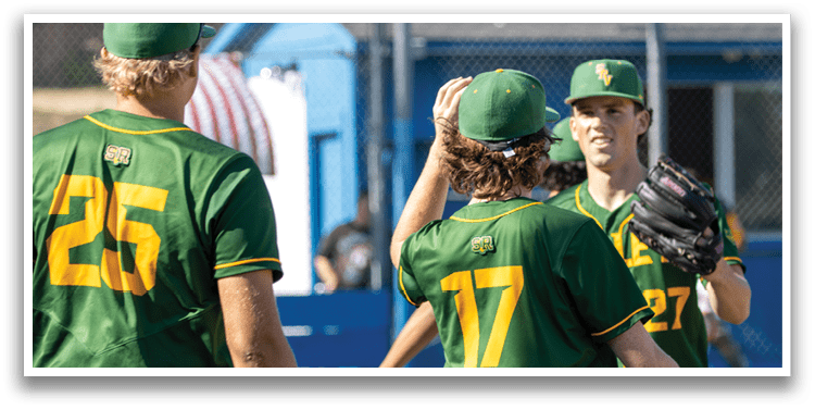 Three men wearing green and yellow baseball uniforms. Description generated by AI