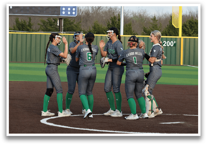 A group of female softball players huddle together on the field. Contenido generado con IA