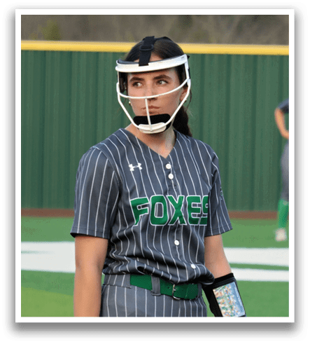 A female baseball player wearing a grey and black uniform stands on the field with a catcher's mitt on her left hand. Contenido generado con IA