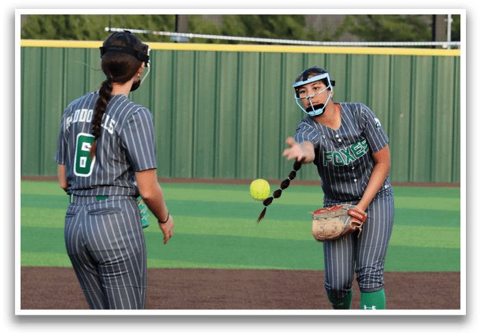 Two girls playing softball, one holding a ball and the other wearing a glove. Contenido generado con IA