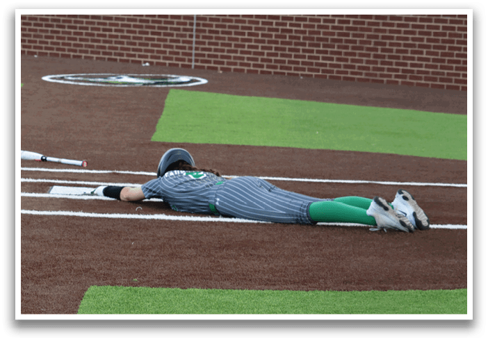 A baseball player is lying on the ground with a bat in her hand. Contenido generado con IA