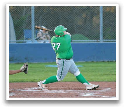 A baseball player in a green shirt and grey pants is swinging a bat at a ball. Contenido generado con IA