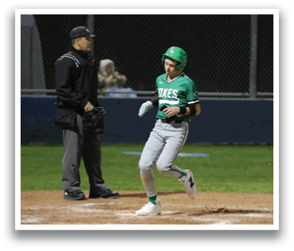 A baseball player is running towards home plate, while an umpire watches from behind. Contenido generado con IA