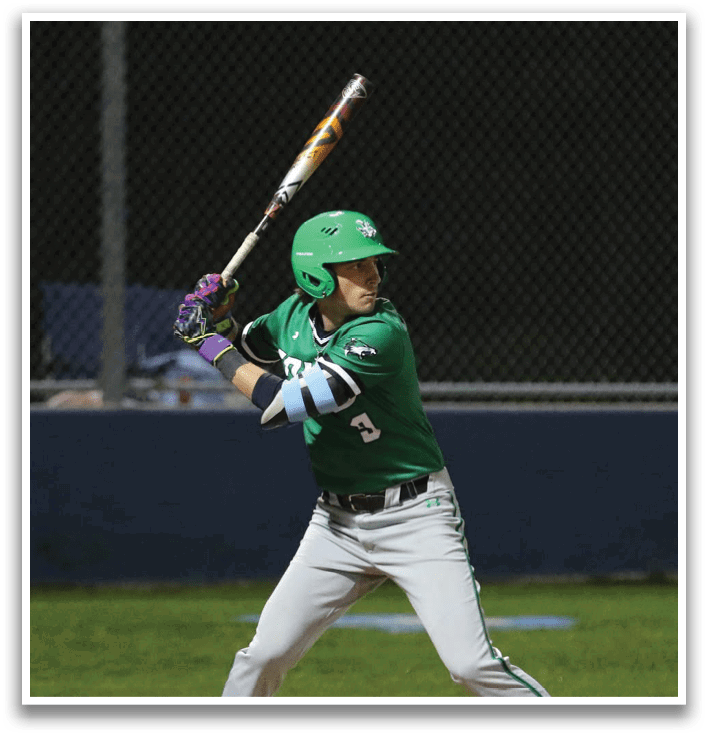 A baseball player in a green shirt and grey pants is swinging a bat at a ball. Contenido generado con IA