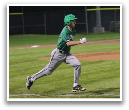A baseball player in a green shirt and grey pants is running towards home plate. Contenido generado con IA