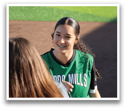 Two girls wearing green shirts and one girl wearing a black shirt are standing on a baseball field. Contenido generado con IA