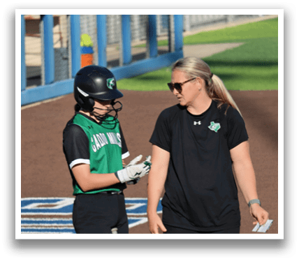 Two women are standing on a baseball field, one of them holding a bat. Contenido generado con IA