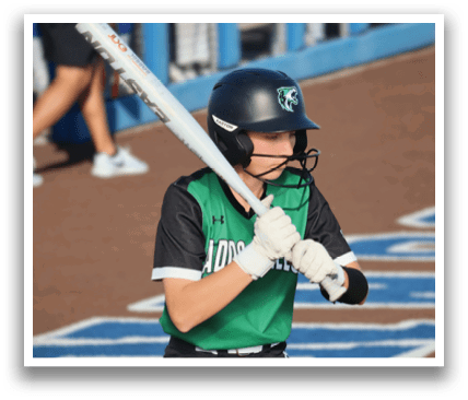 A female baseball player in a green and black uniform holding a bat, ready to swing. Contenido generado con IA