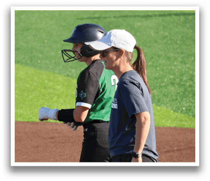Two women on a baseball field, one wearing a helmet and the other with a watch. Contenido generado con IA