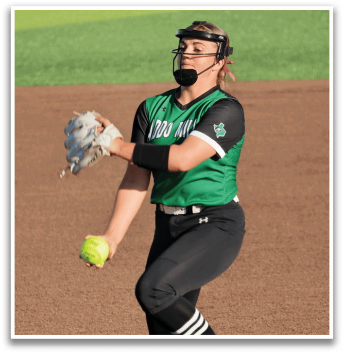 A female baseball player in a green and black uniform is about to throw a ball. Contenido generado con IA