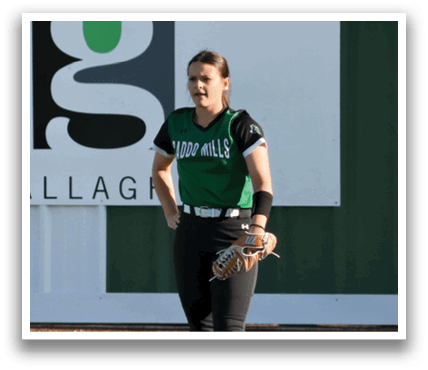 A woman in a green shirt and black pants stands on a baseball field. Contenido generado con IA