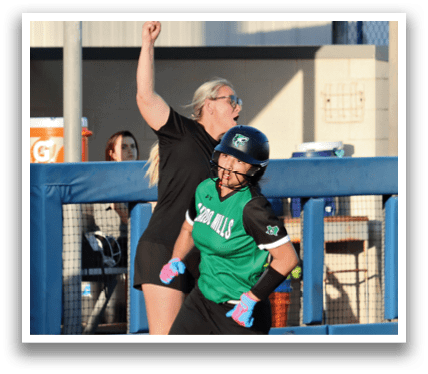 A woman in a green shirt and black shorts is running on a baseball field. Contenido generado con IA